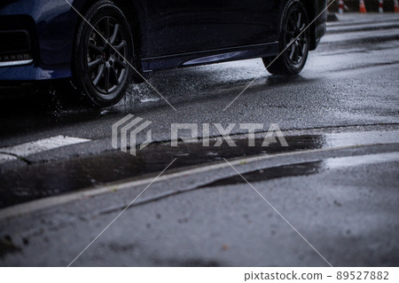 A car running on a rainy road A car running on a rainy road 89527882