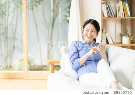 Middle woman smartphone living room 89530750