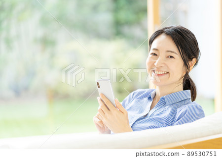Middle woman smartphone living room 89530751