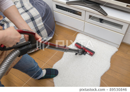 [Middle housewife cleaning rugs with a cyclone cleaner] 89530846