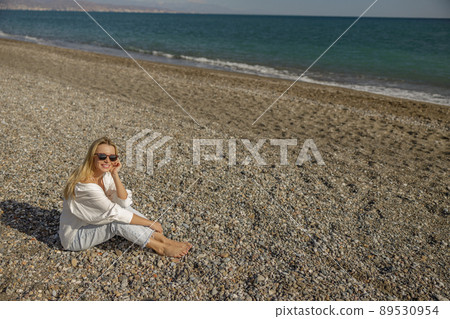 Smiling lady on vacation relaxing on the beach on a sunny summer day 89530954