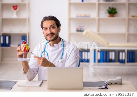 Young male doctor cardiologist working in the clinic Young male doctor cardiologist working in the clinic 89532337
