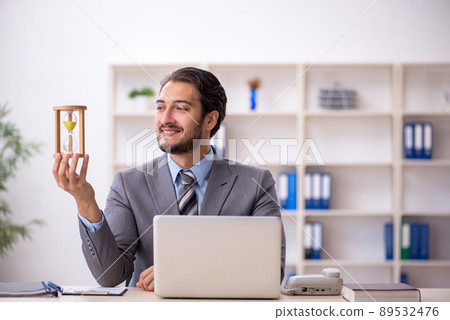 Young male employee in time management concept Young male employee in time management concept 89532476