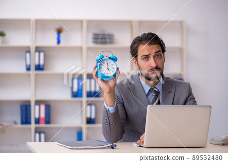 Young male employee in time management concept Young male employee in time management concept 89532480