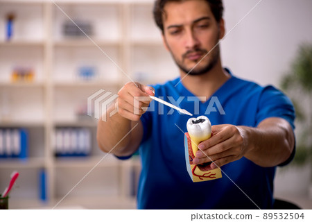 Young male dentist working in the clinic 89532504