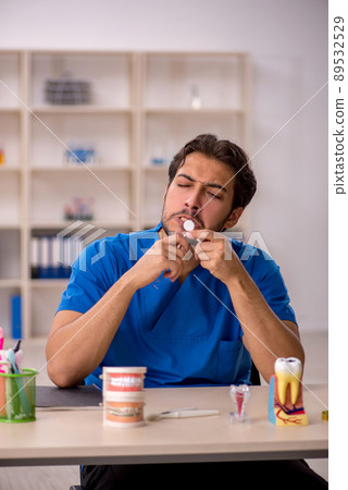 Young male dentist working in the clinic Young male dentist working in the clinic 89532529