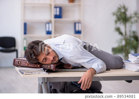 Young male employee in oversleeping concept Young male employee in oversleeping concept 89534081