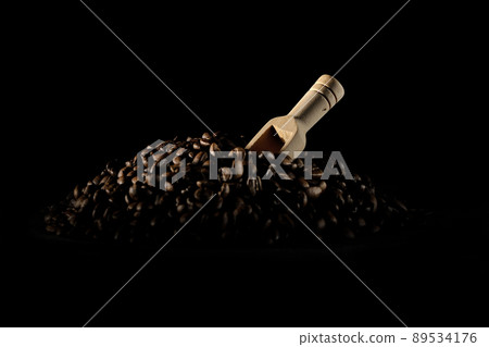 Photographed coffee beans and a measuring spoon on a black background 89534176