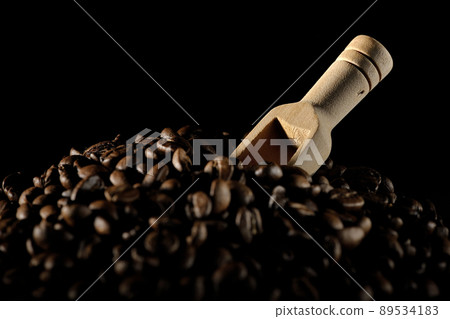Photographed coffee beans and a measuring spoon on a black background 89534183
