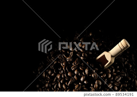 Photographed coffee beans and a measuring spoon on a black background 89534191