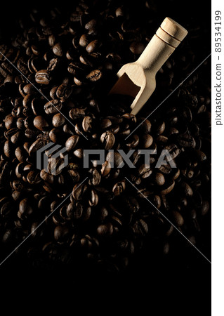 Photographed coffee beans and a measuring spoon on a black background 89534199