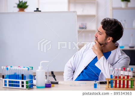 Young male chemist working at the lab 89534363