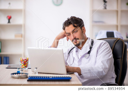 Young male doctor working in the clinic Young male doctor working in the clinic 89534934