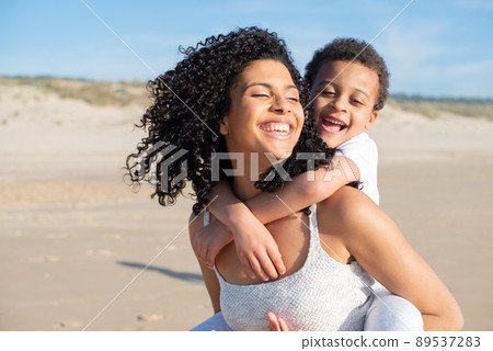 Contented mother and son spending time on beach Contented mother and son spending time on beach 89537283