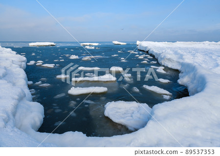 Snowy shore of calm sea Snowy shore of calm sea 89537353