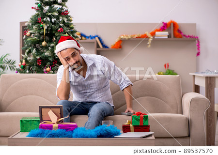 Young man celebrating Christmas at home alone Young man celebrating Christmas at home alone 89537570