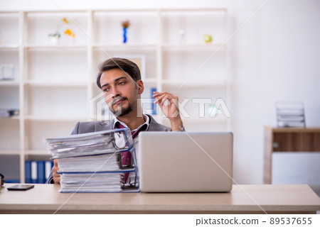 Young male employee working in the office Young male employee working in the office 89537655