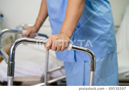 Asian lady woman patient walk with walker at nursing hospital ward, healthy strong medical concept Asian lady woman patient walk with walker at nursing hospital ward, healthy strong medical concept 89538397