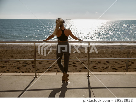 Standing young fit sportswoman watching beautiful sea 89538938