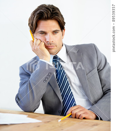 Needing a change in career. Bored young businessman sitting at his desk. Needing a change in career. Bored young businessman sitting at his desk. 89539357