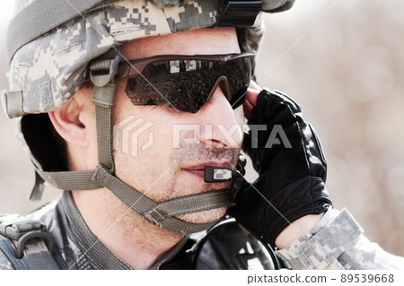Keeping communication on command. Closeup profile of a soldier communicating on his headset. Keeping communication on command. Closeup profile of a soldier communicating on his headset. 89539668
