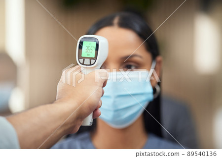 No sign of fever here. Cropped shot of an attractive young businesswoman wearing a mask and having her temperature taken while standing at the head of a queue in her office. No sign of fever here. Cropped shot of an attractive young businesswoman wearing a mask and having her temperature taken while standing at the head of a queue in her office. 89540136