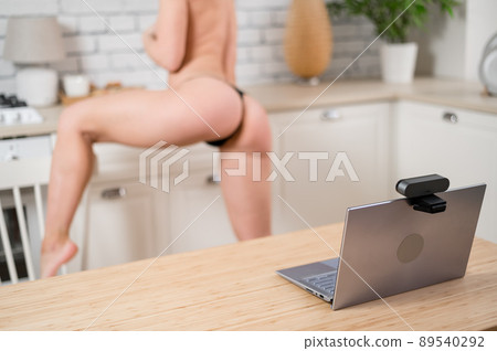 A girl in underwear flirts on an online video connection on a laptop. Woman working as a web cam model A girl in underwear flirts on an online video connection on a laptop. Woman working as a web cam model 89540292