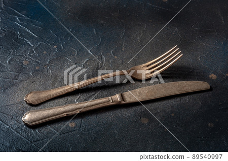 Cutlery. A knife and fork on a black slate background. Modern silverware Cutlery. A knife and fork on a black slate background. Modern silverware 89540997