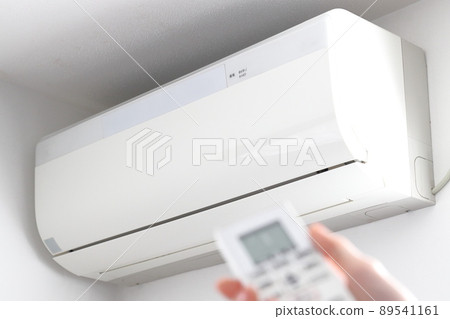 白色空調和手來操作遙控器 89541161