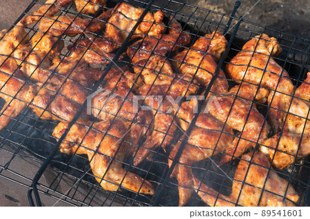 Grilled chicken wings. cooking fry shish kebab,BBQ, barbecue, shashlik or meat on coals. Cooking meat in the grill on skewers in nature in the summer on a picnic. Pork on the grill Grilled chicken wings. cooking fry shish kebab,BBQ, barbecue, shashlik or meat on coals. Cooking meat in the grill on skewers in nature in the summer on a picnic. Pork on the grill 89541601