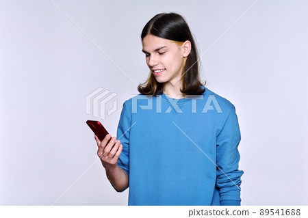 Guy with smartphone in his hand, on light studio background Guy with smartphone in his hand, on light studio background 89541688