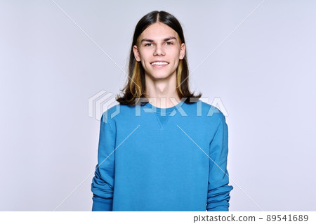 Portrait of smiling positive male looking at camera on light background 89541689