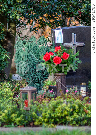 Facemask lying on grave of family members with a facemask during the pandemic Facemask lying on grave of family members with a facemask during the pandemic 89541799