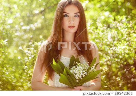 Portrait of beautiful young woman with lily of the valley Portrait of beautiful young woman with lily of the valley 89542365