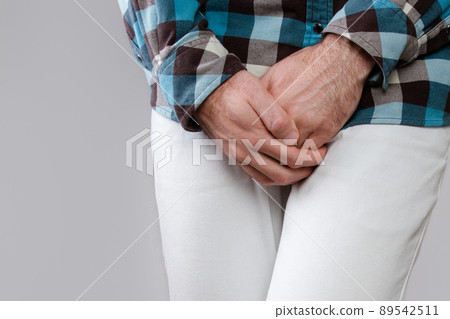 Concept of male sexual diseases. The man holds hands for genitals. Testicular cancer. Close up 89542511
