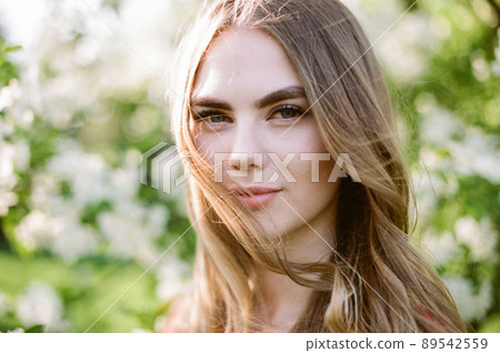 Beautiful young woman in summer garden Beautiful young woman in summer garden 89542559