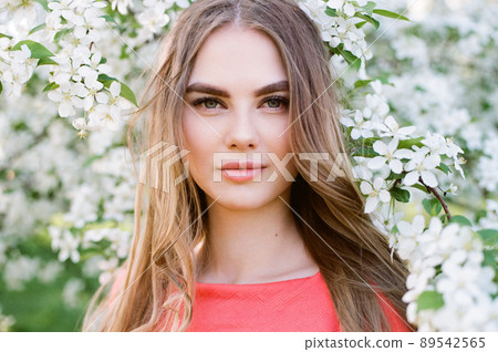 Beautiful young woman in summer garden Beautiful young woman in summer garden 89542565