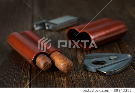 View of a leather case with two Cuban cigars, a lighter and a cutter. 89543392
