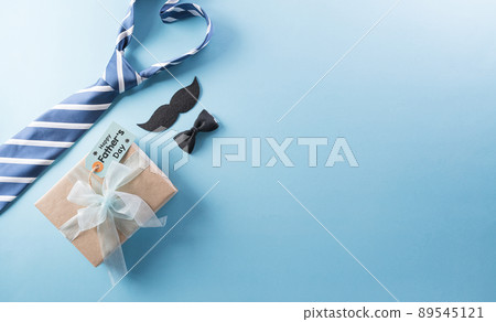 Happy Fathers Day background concept with gift box, decorated bow tie, necktie and mustache on bright pastel background. 89545121