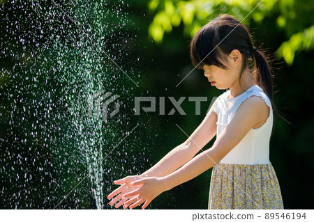 A cute elementary school girl drinking tap water in a park in the middle of summer A cute elementary school girl drinking tap water in a park in the middle of summer 89546194
