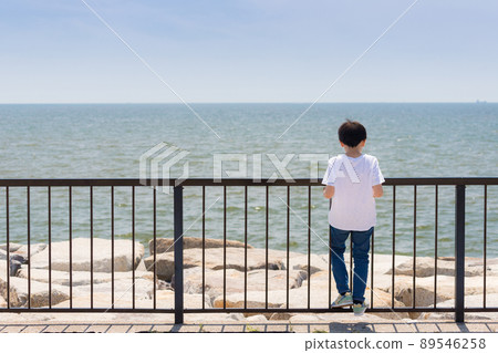 A child playing on the embankment of the summer coast A child playing on the embankment of the summer coast 89546258