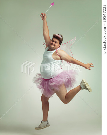 Showing his "lighter" side. An overweight man comically dressed-up in a pink fairy costume. Showing his "lighter" side. An overweight man comically dressed-up in a pink fairy costume. 89547222