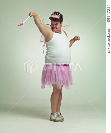 You get some love today. An overweight man comically dressed-up in a pink fairy costume. 89547234
