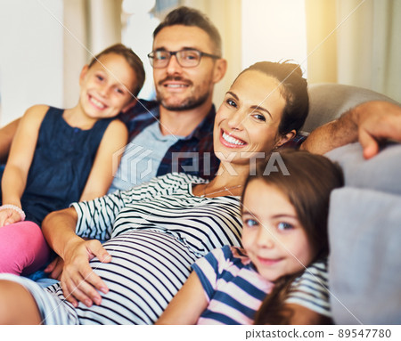 Happiness is time with the family. Cropped portrait of a happy young family of four relaxing on the sofa in their home. 89547780