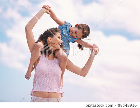 Spending quality time with mom. A little girl and her mother at the beach. 89548910