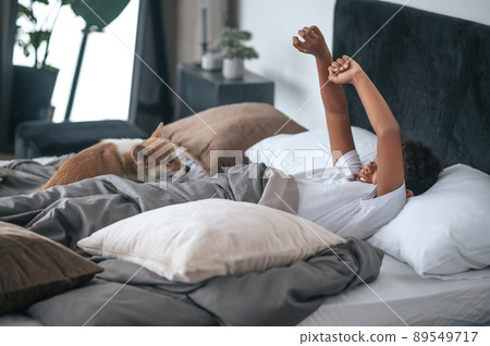 A boy laying in bed and a dog together with him A boy laying in bed and a dog together with him 89549717