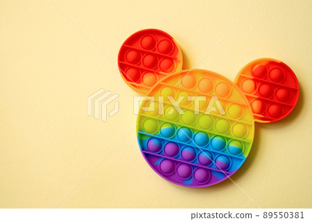 Bright colorful popit toy on a yellow background. pop it toy. simple dimple. Bright colorful popit toy on a yellow background. pop it toy. simple dimple. 89550381