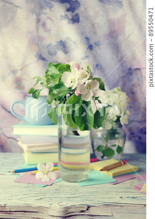 Back to school, bouquet of apple tree flowers, stack of books, cup of tea, and stationery on wooden table, texture wall background Back to school, bouquet of apple tree flowers, stack of books, cup of tea, and stationery on wooden table, texture wall background 89550471