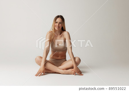 Portrait of a young woman wearing underwear, full length stock