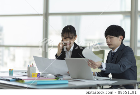 穿著西裝的年輕男女一邊打電話一邊開會 穿著西裝的年輕男女一邊打電話一邊開會 89551191